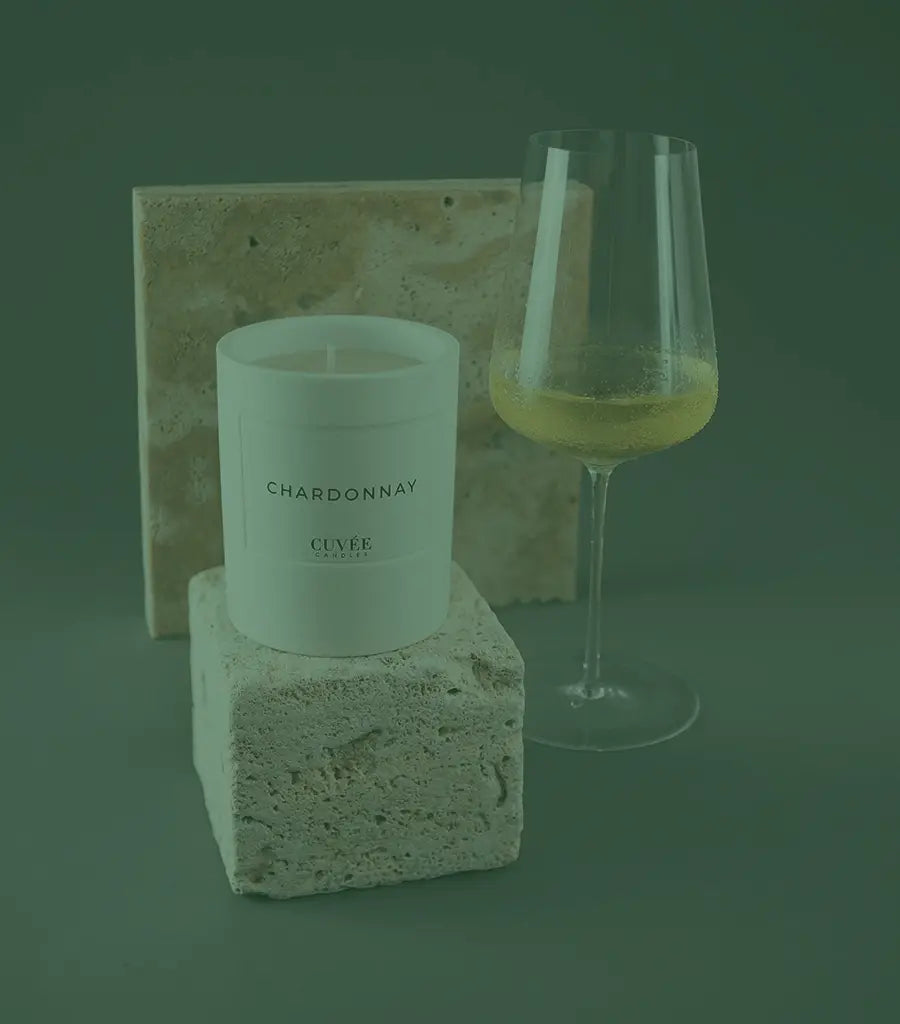 Weinglas mit Kerze auf Stein.