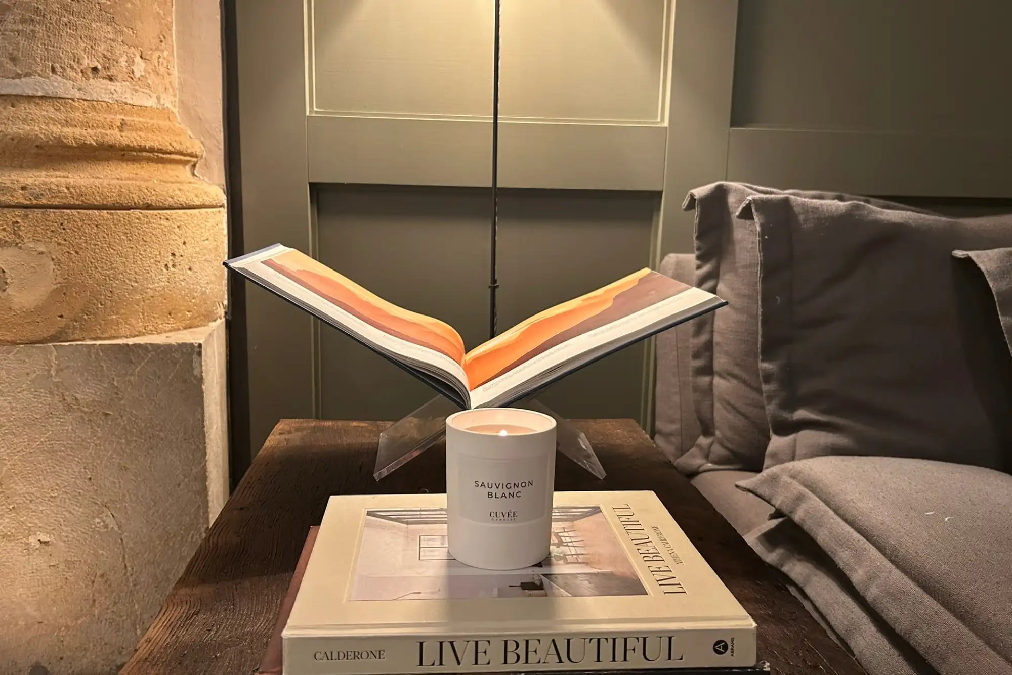 Brennende Kerze auf einem Coffeetable Book.