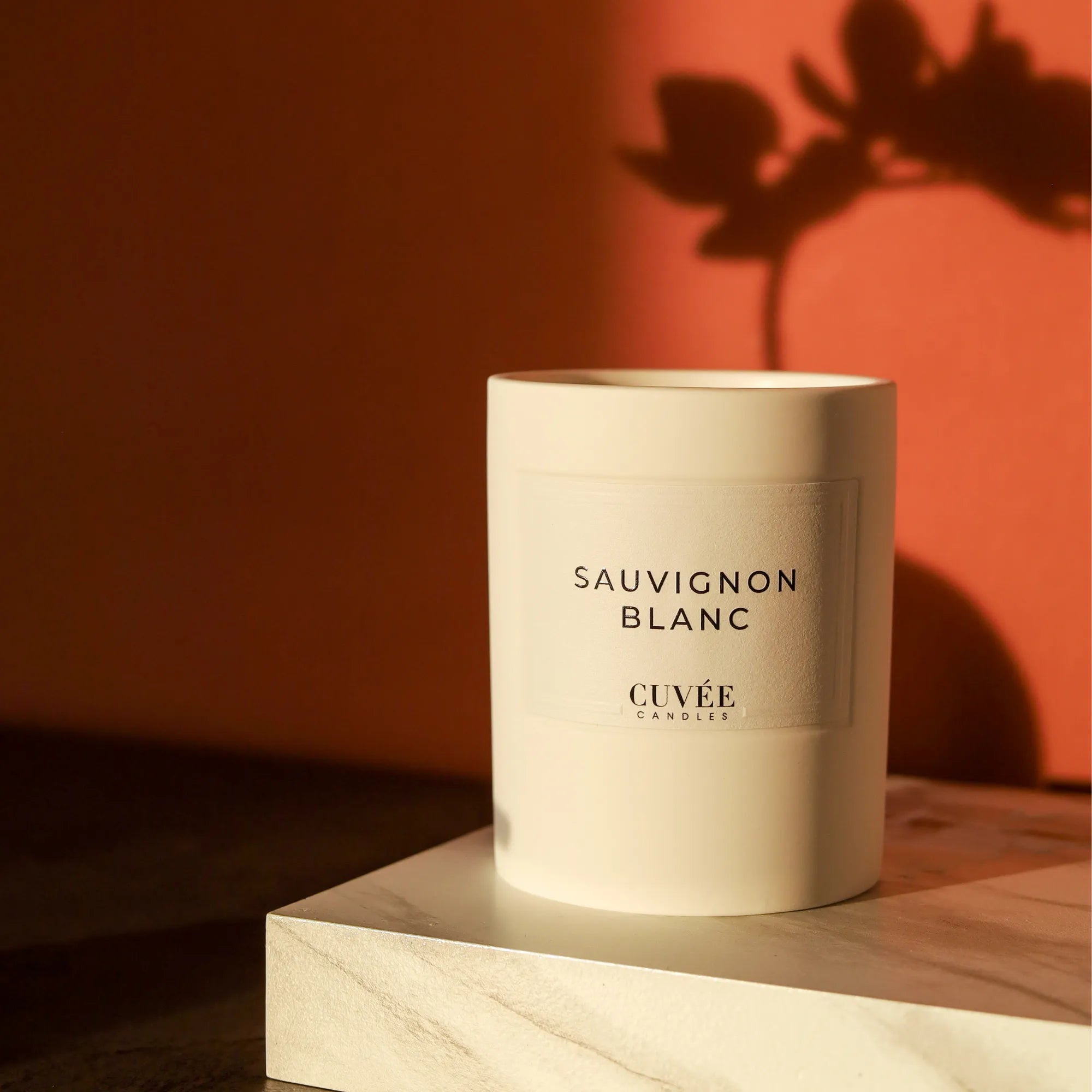 Duftkerze auf Marmortablett mit Schatten