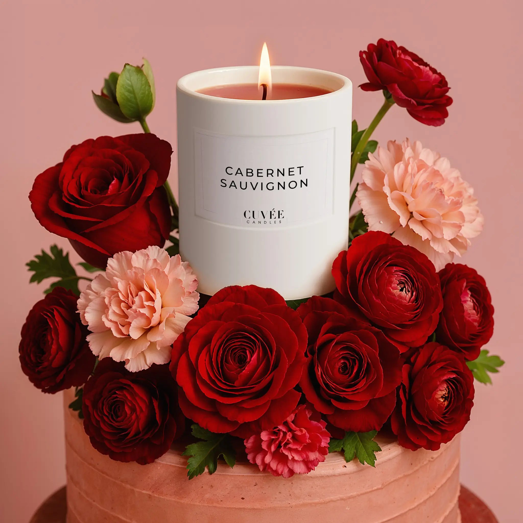 Muttertags-Edition von CUVÉE CANDLES auf Torte, angerichtet mit edlen Blumen.