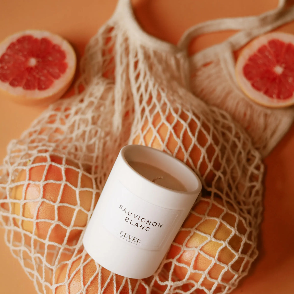 CUVÉE Duftkerze Sauvignon Blanc in einem Einkaufsnetz mit Grapefruits