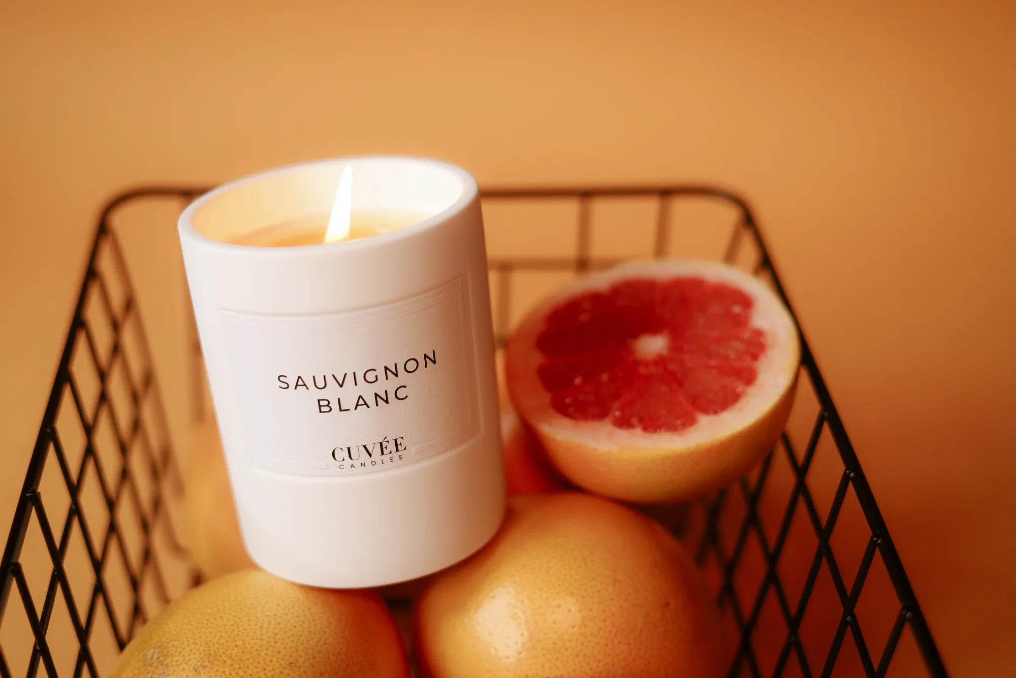 Brennende Kerze mit Grapefruit im Korb
