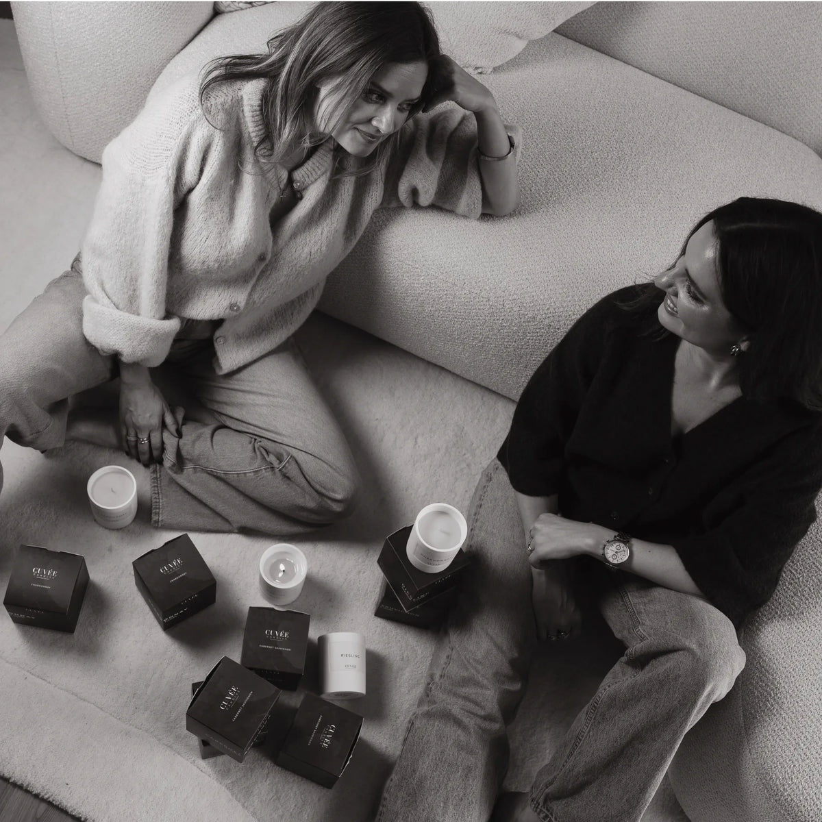 Die beiden Gründerinnen Miriam und Katharina Stebel im Gespräch auf dem Sofa, umgeben von Duftkerzen